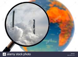 Chimneys-covered-in-smoke-seen-through-magnifying-glass-held-against-BRA2F5.jpg